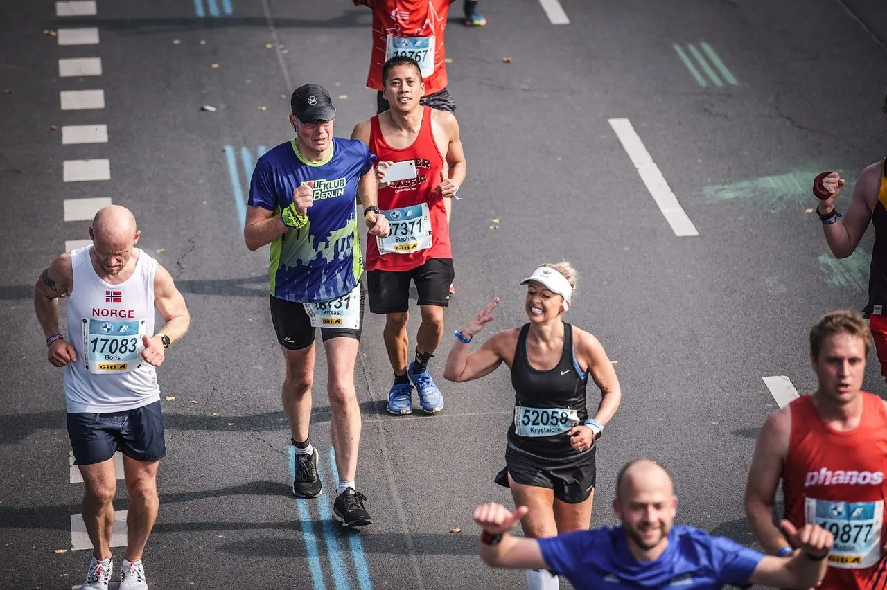Krystalore Crews smiling and waving to the crowd mid-marathon