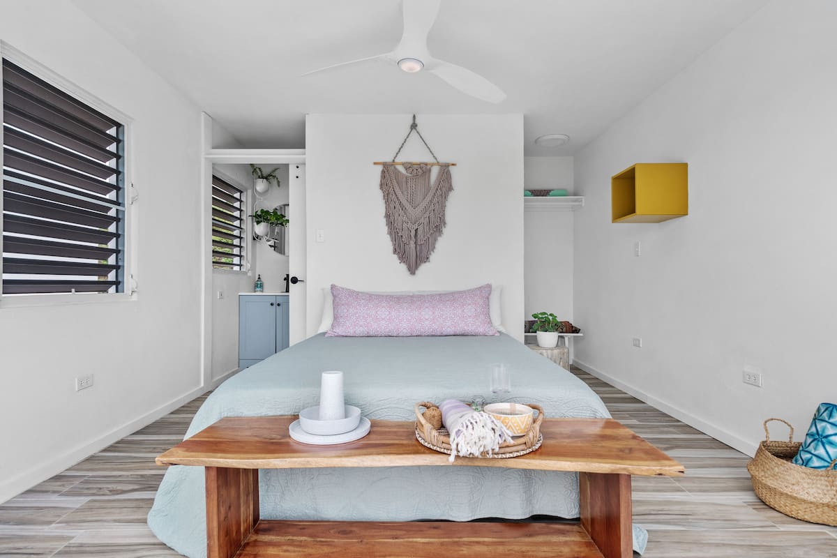 Minimalist guest casita bedroom with queen bed and macramé decor