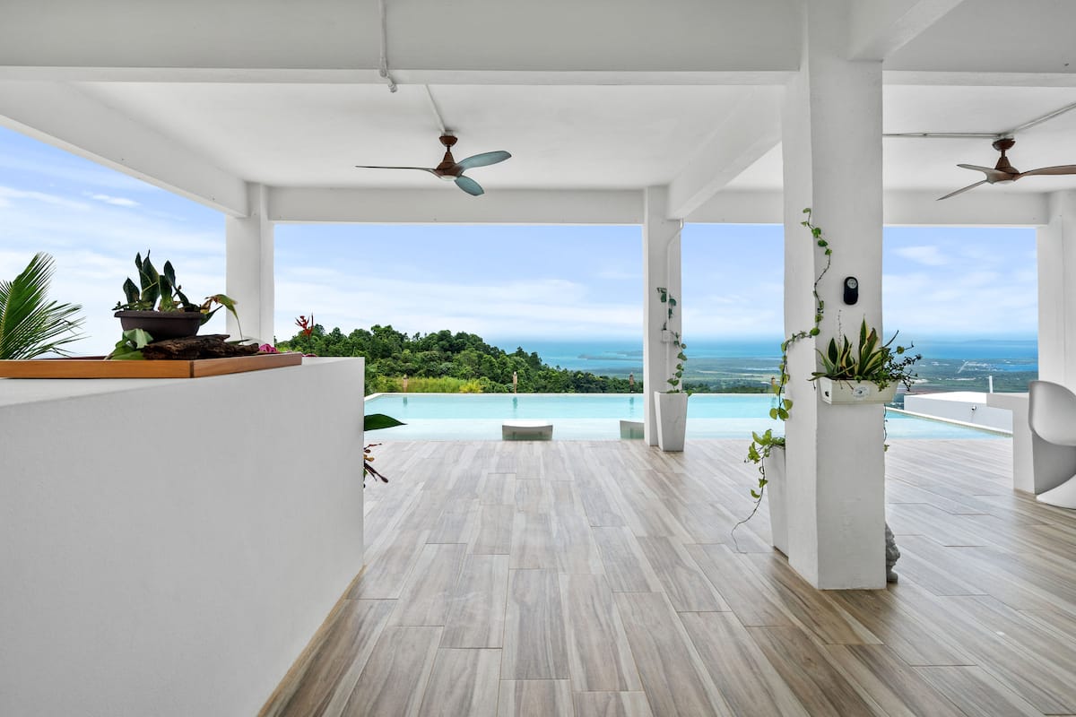 Open-air covered terrace with infinity pool overlooking ocean and rainforest