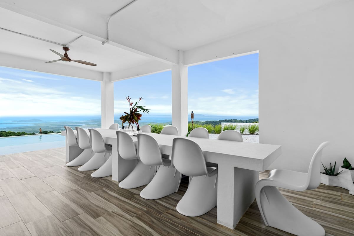 Covered outdoor dining area with panoramic ocean and jungle views seating 14