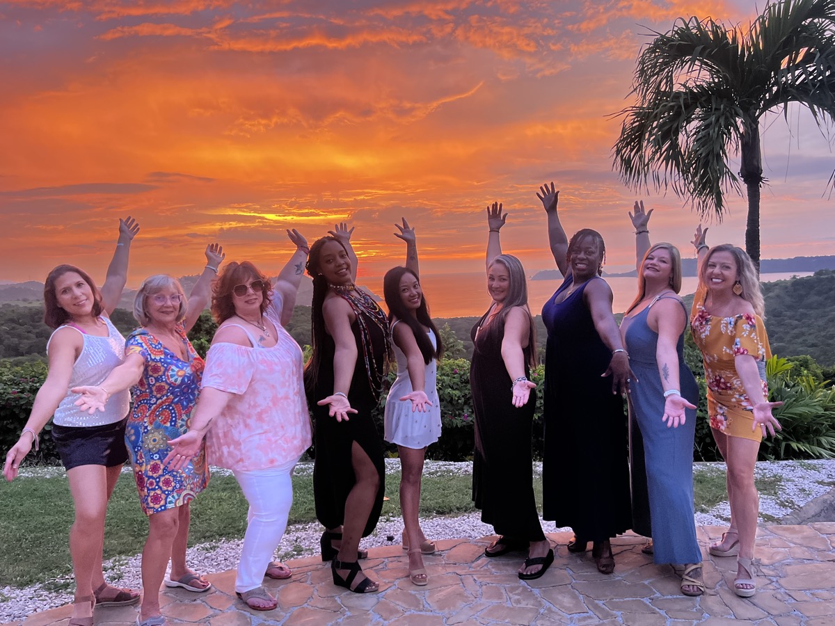 Retreat women celebrating at sunset with ocean views